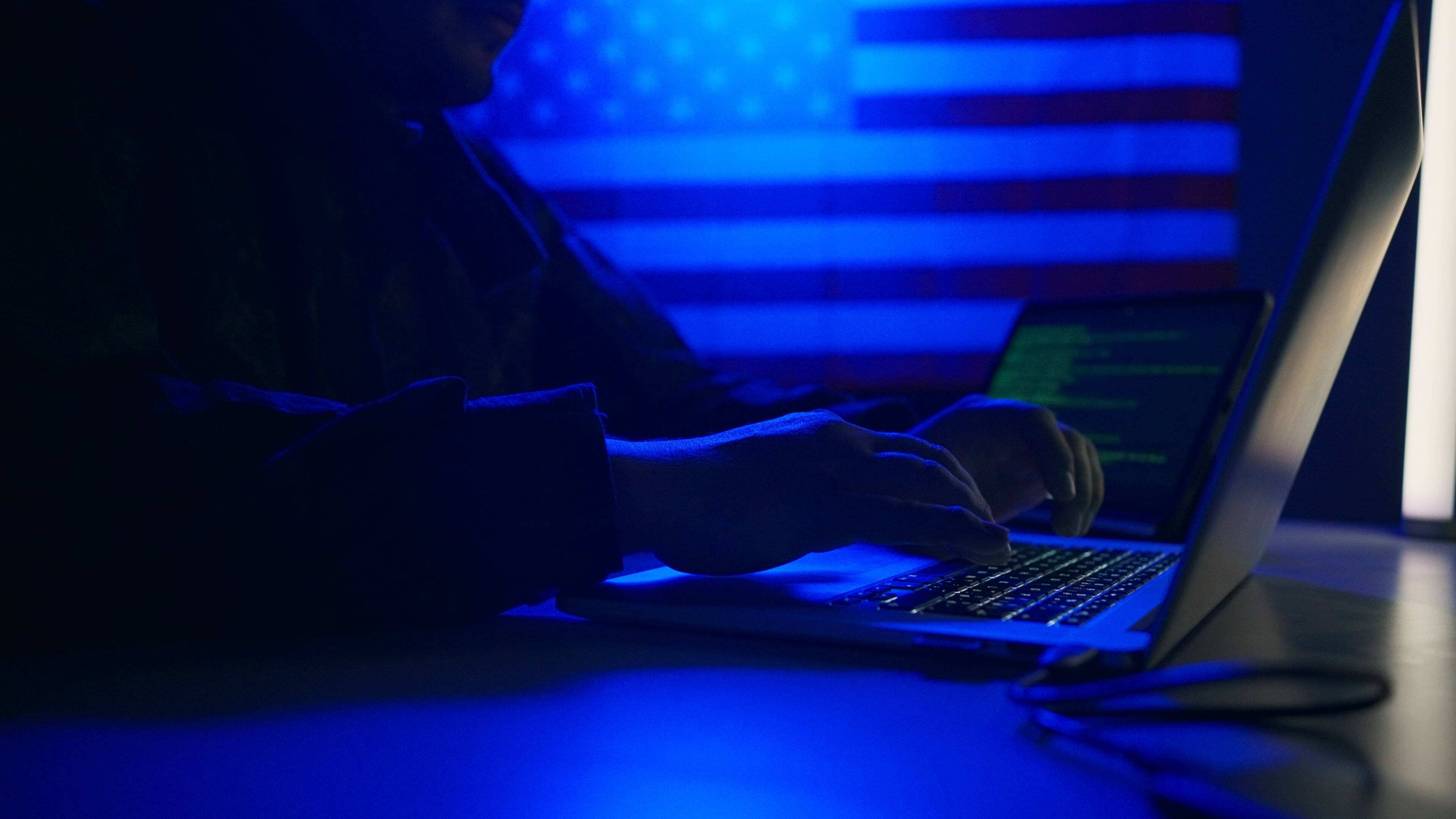 hacker-with-laptop-and-usa-flag-in-background